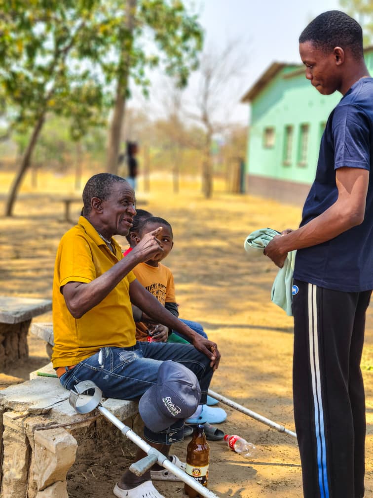 A volunteer washing clothes for an elder outside her home